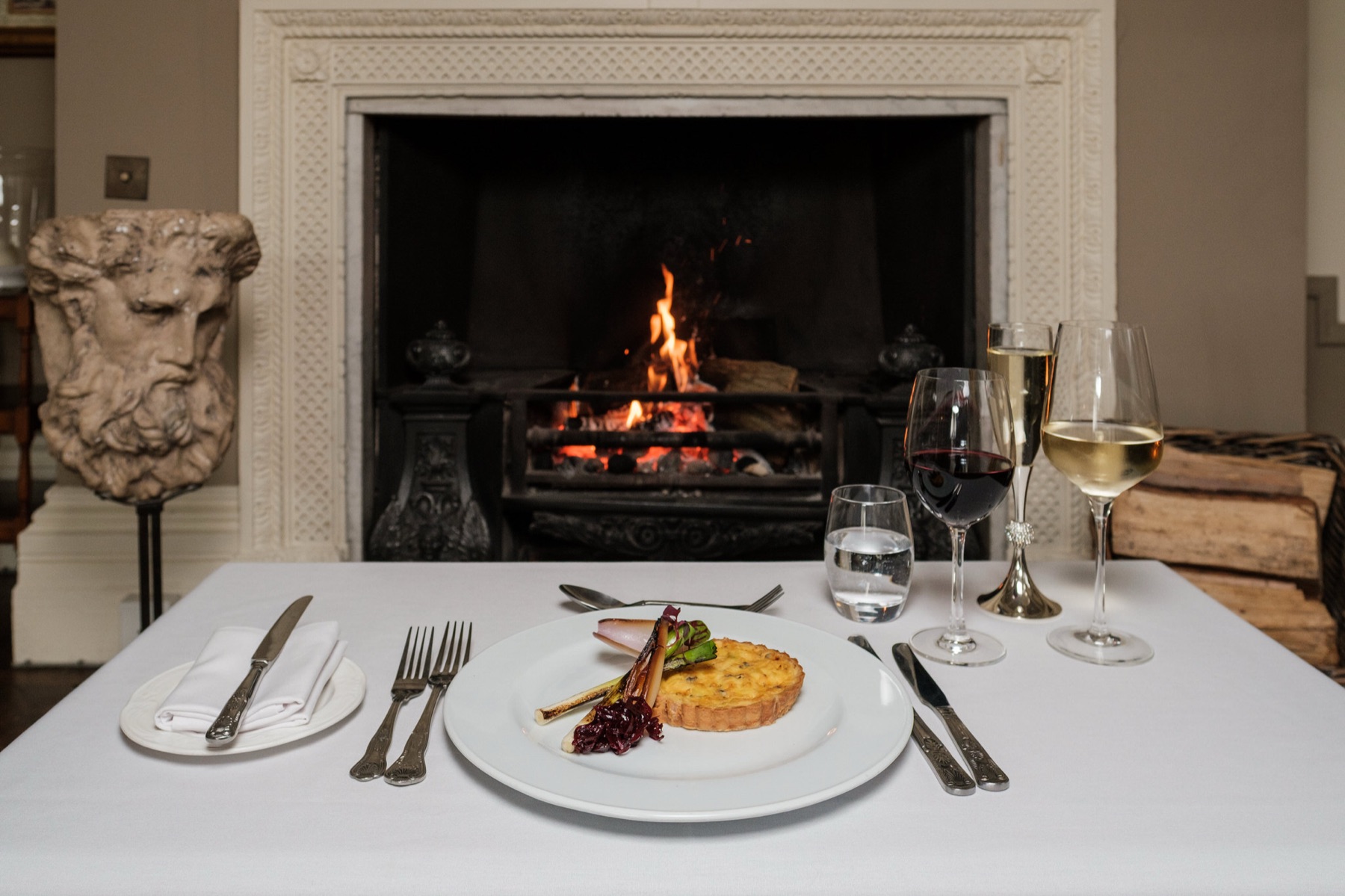 A plated course set before the marble fireplace at Glewstone Court